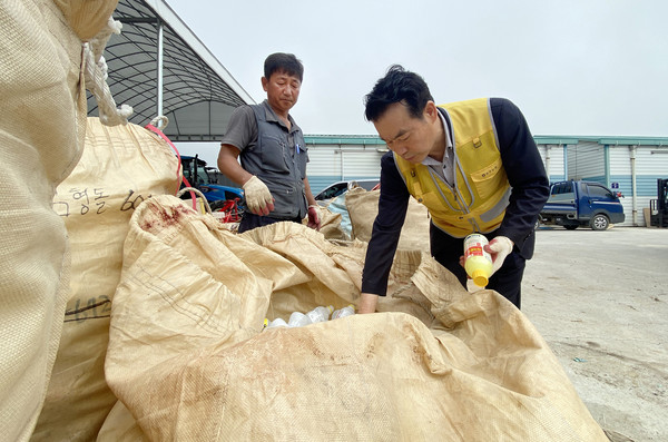 임용식 조합장(오른쪽)과 노재국 농업경영인 송포지구회장(왼쪽)이  분리수거를 하며 이야기를 나누고 있다.