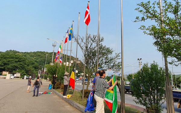 한국전쟁 참전국들의 국기를 교체하고 있는 관산동 주민자치회 위원들.