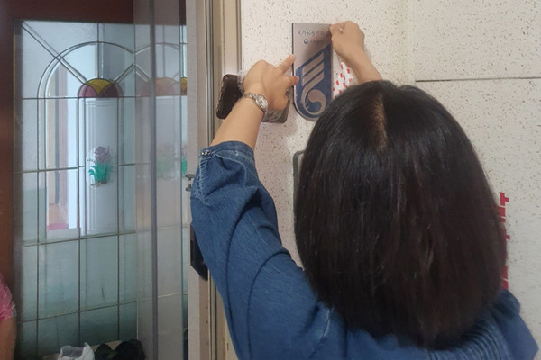 국가 유공자 가정에 국가유공자 명패를 달고 있는 탄현1동 관계자