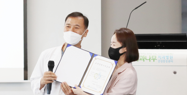 김혜성 이사장이 김명희 을지대학교 치위생학과 교수(사진 오른쪽)에게 교육장학금 기부증서를 전달하고 기념촬영을 하고있다.