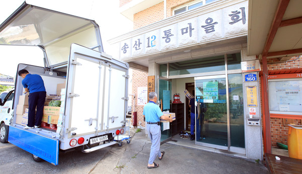 전달된 물품을 함께 운반하고 있는 송포농협 직원과 마을 주민들.