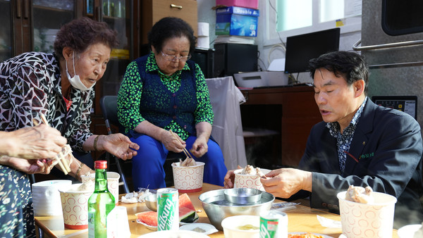 임용식 조합장이 지역의 어르신들과 삼계탕을 나누고 있다.