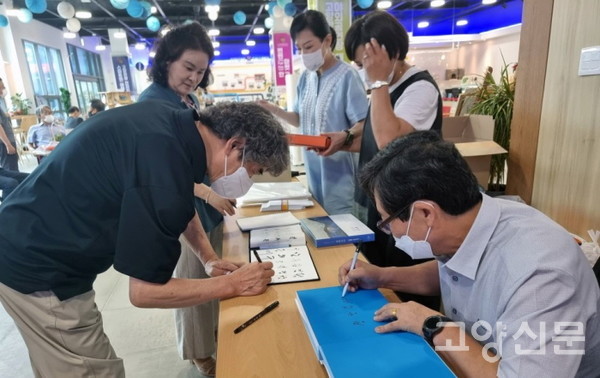 신간 사진작품집 출판기념회에서 사인을 하고 있는 이재용 작가. [사진=김정호]