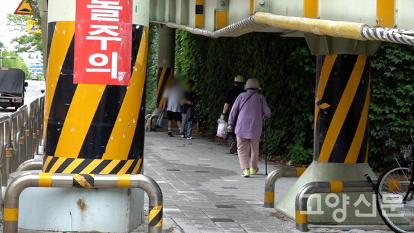 머리를 숙이고 경사로 아래로 걸어다녀야 하는 보행자들. 