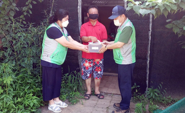 화정2동이 지역의 독거어르신에게 케이크를 전달하며 안부를 확인하고 있다.