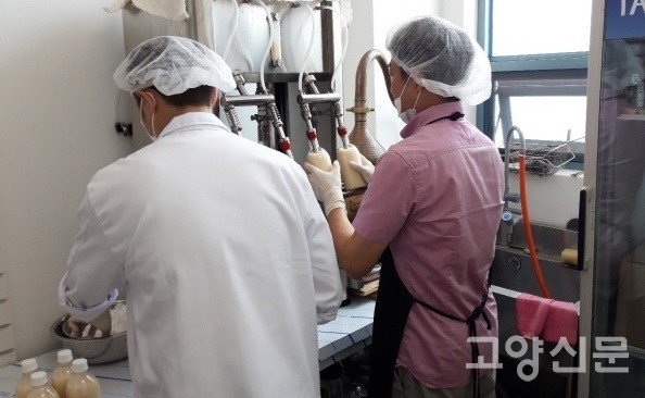 맛있게 익은 막걸리를 병에 담고 있는 박 대표 부자. 