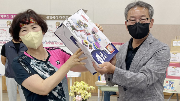 조명휘 고봉동 주민자치회장(오른쪽)이 출전 선수에게 경품을 전달하고 있다.