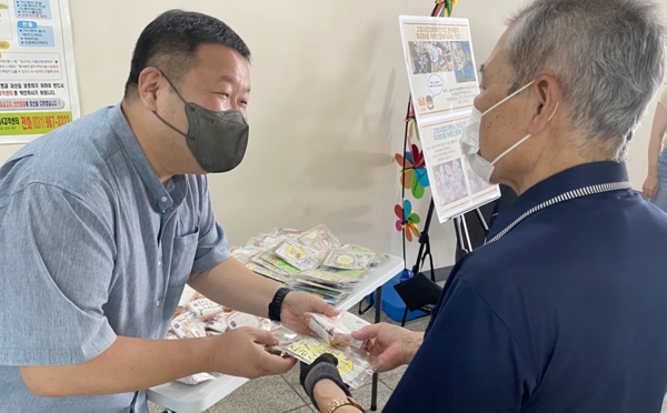 양복선 향동종합사회복지관장(왼쪽)이 나눔에 동참해 어르신에게 나눔을 하고 있다.