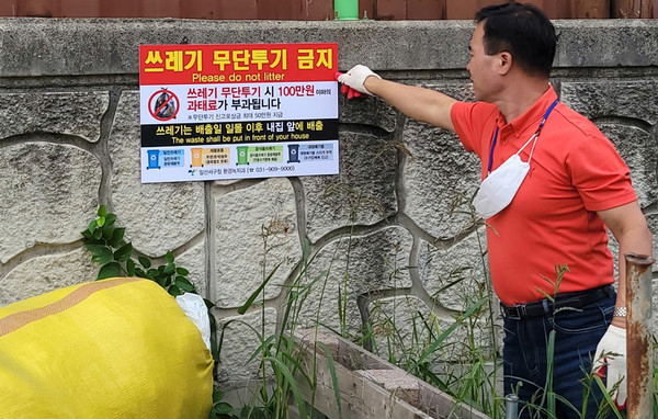 가좌동 관계자가 쓰레기 무단투기금지 스티커를 부착하고 있다.