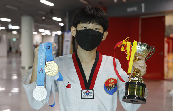  충무태권도체육관 소속 손준호(내유초·6)군이 트로피와 메달을 들고 포즈를 취했다. 손 선수는 "오늘 너무 기쁘고 충무태권도가 우승해 정말 좋다. 태권도를 꾸준히 해 좋은 선수가 되겠다"라고 했다