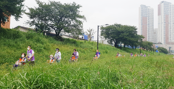거동이 불편한 어르신들이 휠체어를 타고 주민들과 함께 창릉천변을 산책하고 있다.