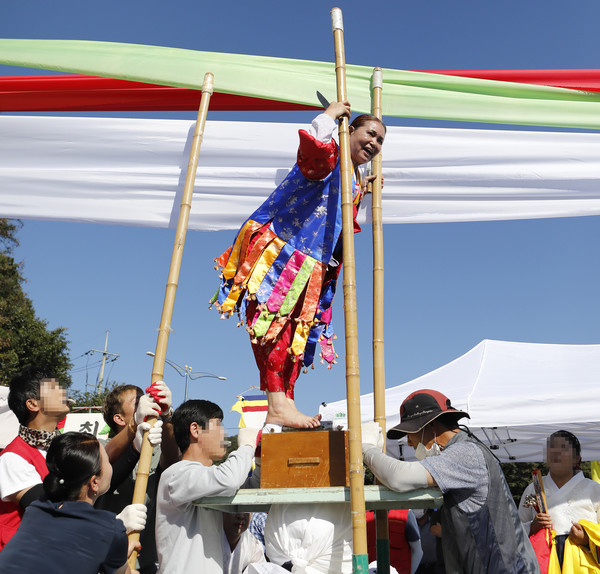 위령굿에서 작두타기를 하고 있다.