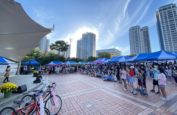 견달산 모꼬지 한마당에서 어린이들과 청소년, 가족, 어르신들이 가수 임지민 학생의 노래를 즐기고 있다.