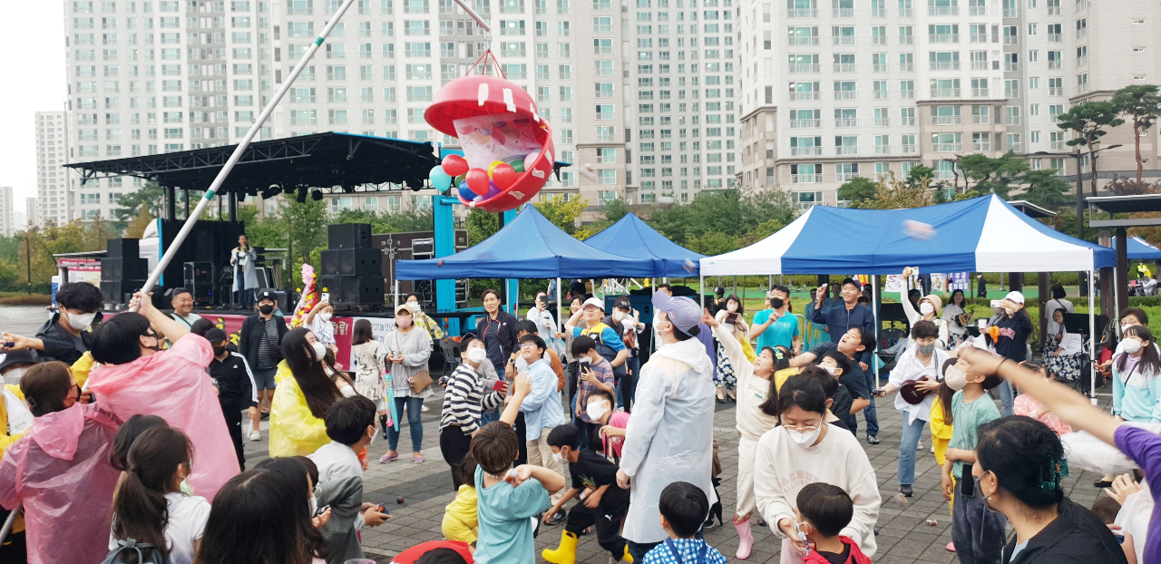 창릉동 용머리 축제 참가자들이 가족걷기대회 출발에 앞서 힘껏 오자미를 던져 박을 터뜨리며 축제의 흥을 즐기고 있다.