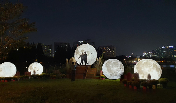 야외 전시 공간 가을의 달을 만끽하는 시민.