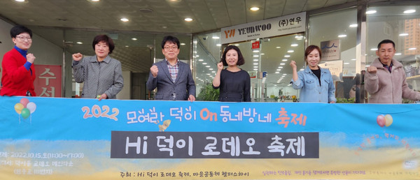 헬퍼스 하이 운영자들과 덕이동 로데오 메인타운 상인회 관계자가 화이팅을 하고 있다.