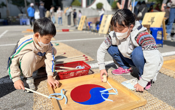  팽이 돌리기를 하는 어린이들