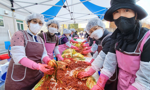 김장 배추에 양념을 넣고 있는 봉사자들.