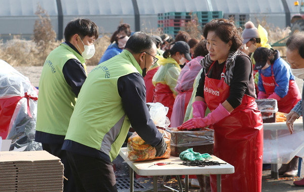 농협 고양시지부 직원들과 이춘자 송포농협 고향주부모임 회장(오른쪽)이 김치를 담고 있다.