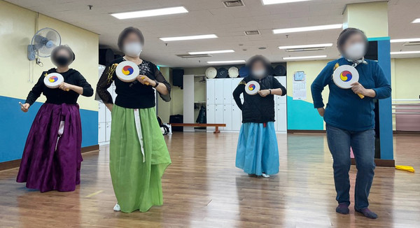 프로그램의 하나로 어르신들이 전통무용 수업에서 소고춤을 추고 있다.