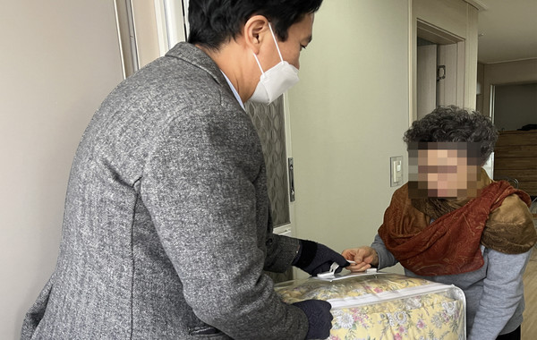 어려운 이웃에게 이불세트를 전달하는 새빛안과병원 관계자.