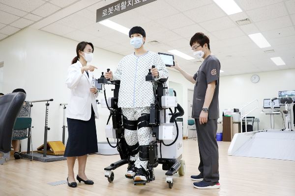 유지현 일산백병원 재활의학과 교수(왼쪽)가 보행 로봇 치료 방법을 설명하고 있다. 