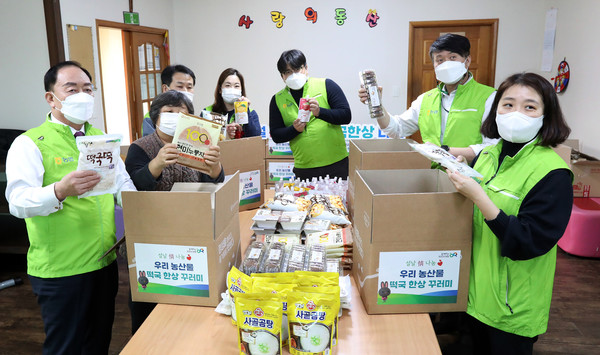 꾸러미에 식료품을 담으며 나눔을 함께한 농협 관계자들.