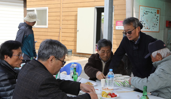 조명휘 감사(고봉동 주민자치회장, 오른쪽 두번째)가 주민들에게 음식을 대접하고 있다.