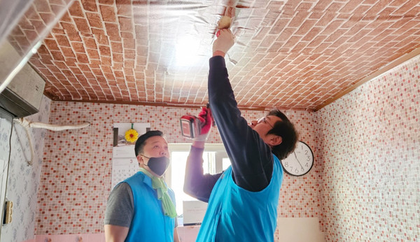 고양로타리클럽 봉사단들이 천장 조명을 교체하고 있다.