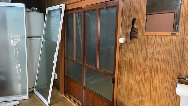  출입문 교체 전, 다소 어둡고 낡은 출입문.