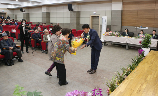 신임 조합장에 꽃다발을 전달하는 조합원들.