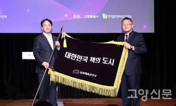 문화체육관광부 김도영 국장(오른쪽)으로부터 책의 도시 선포를 알리는 상징기를 전달받는 이동환 고양시장.