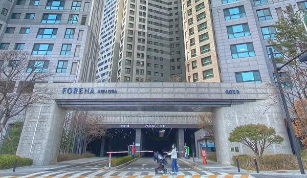 포레나 킨텍스로 브랜드 변경이 된 게이트 앞으로 주민이 지나가고 있다.