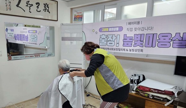 봉사자가 한 어르신에게 헤어 미용을 하고 있다.