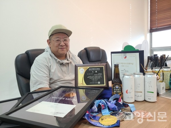 각종 주류 시상식에서 받은 상패와 메달을 보여주고 있는 더테이블 브루잉 컴퍼니 윤재원 이사. [사진=조문주 기자]