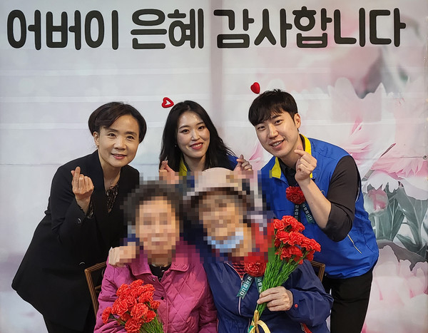 심재경 관장(왼쪽)과 직원들이 어르신들과 함께 사랑해 孝를 하고 있다.