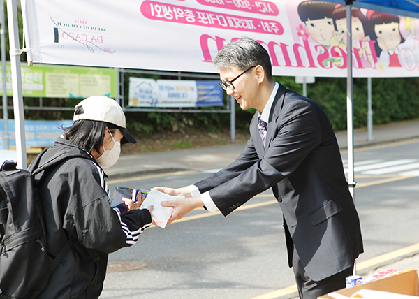 이정열 중부대 총장이 15일 스승의 날 아침 등굣길 학생에게 베이글 샌드위치와 음료를 전하고 있다. [사진 = 중부대학교]