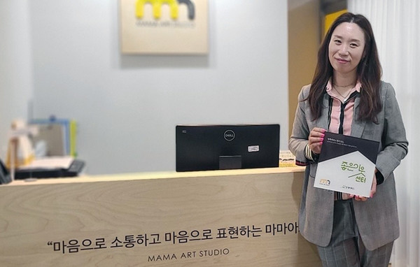 굿네이버스 경기2본부는 경기도 고양시에 위치한 마마아트스튜디오와 ‘좋은이웃센터’ 현판 전달식을 진행했다. ‘좋은이웃센터’현판을 들고 있는 마마아트스튜디오 엄혜지 센터장.사진제공=굿네이버스 경기2본부)