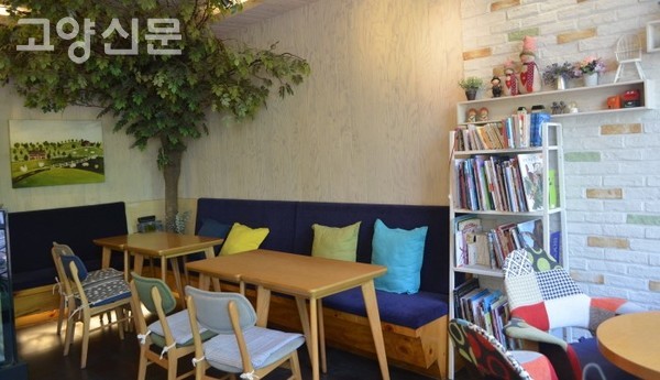 편안한 테이블과 책꽂이가 놓인 실내 좌석. 