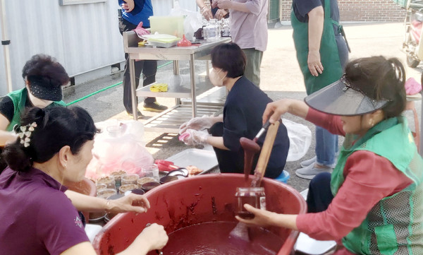 성사1동 새마을부녀회들이 어려운 이웃에게 전달할 고추장을 담고 있다.