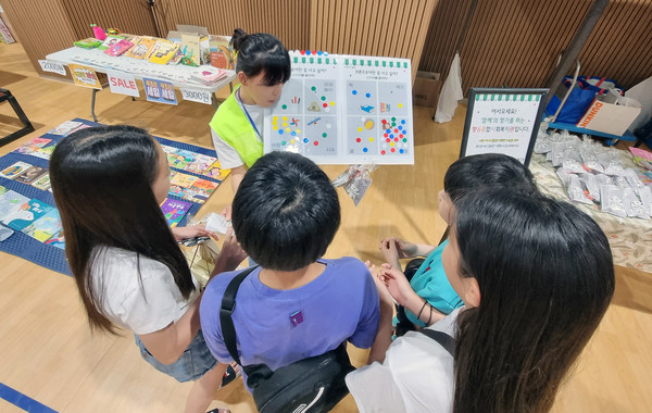 아이들이 향동종합사회복지관 부스 이벤트에 참여하고 있다.