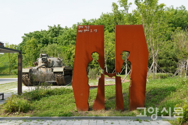 통일촌 군막사를 리모델링한 '나들라온' 주차장에 서 있는 평화 조형물. 뒤편에 실물 탱크도 전시되어있다. 