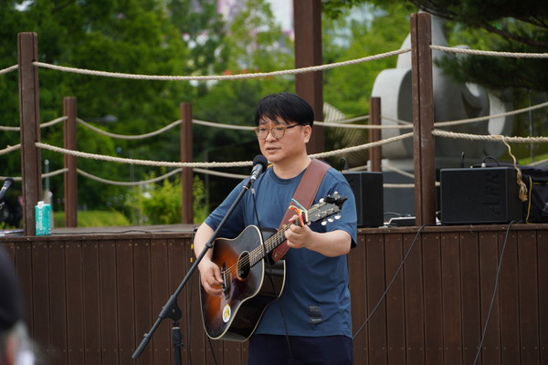 박정환씨가 통기타로 노래하고 있다.
