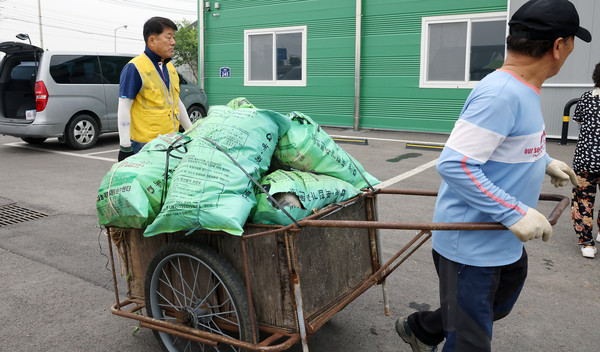 인력거에 농업용 폐자재를 싣고 오는 농민.