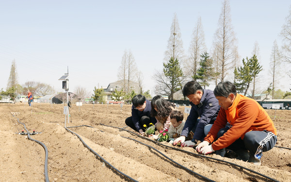 지난 봄 스마트팜 분양자 가족과 심민보 송포농협 조합장(가운데)과 윤현철 대표(오른쪽)가 함께 자리했다.