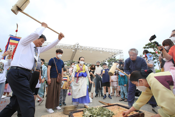 김용규 원장(왼쪽)이 단오축제에서 시민들과 함께 나눌 떡메를 치고 있다.