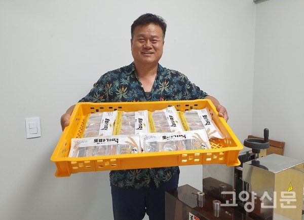 김한원 대표가 국내산 곡물과 쌀로 만든 가래떡을 들어보이고 있다.