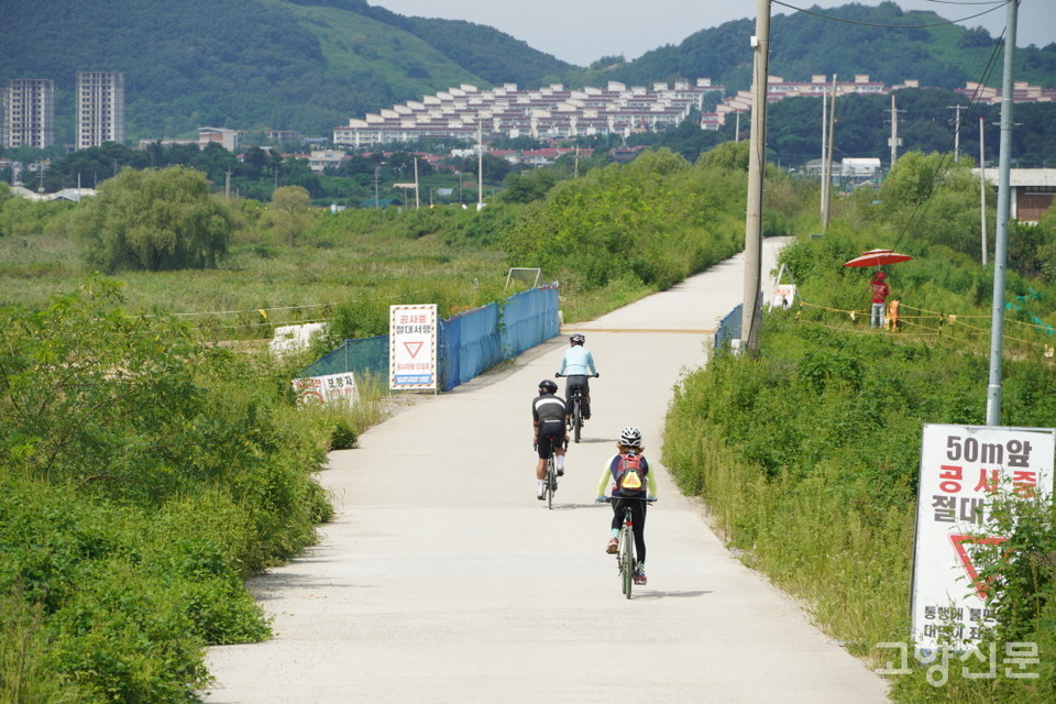 공사중인 둑방길을 따라 자전거 라이딩을 즐기는 사람들.  