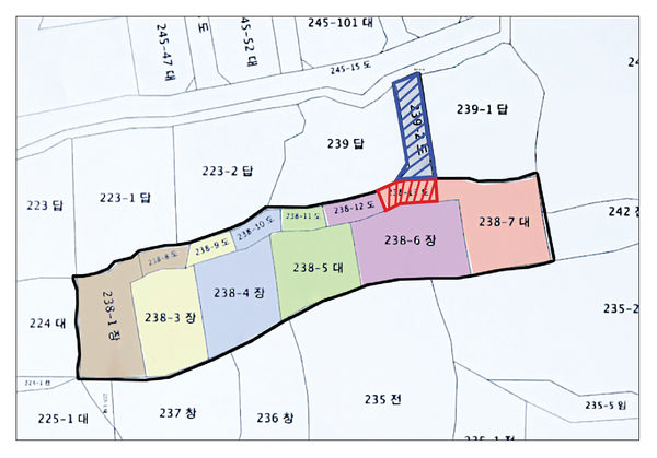 파란색으로 빗금 친 부분이 주민 6명이 공동으로 소유한 도로, 붉은색으로 빗금 친 부분은 첫 번째 땅주인 소유의 도로.