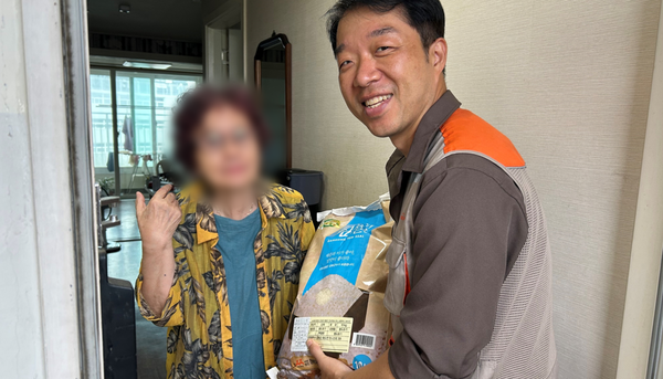  지역 단체에게 지원받은 쌀을 저소득층 어르신에게 전달하는 나눔 관계자.